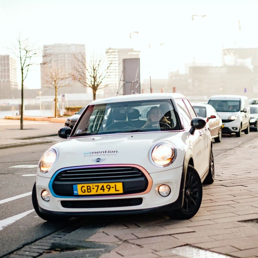 Een witte Mini Cooper op een parkeerplaats